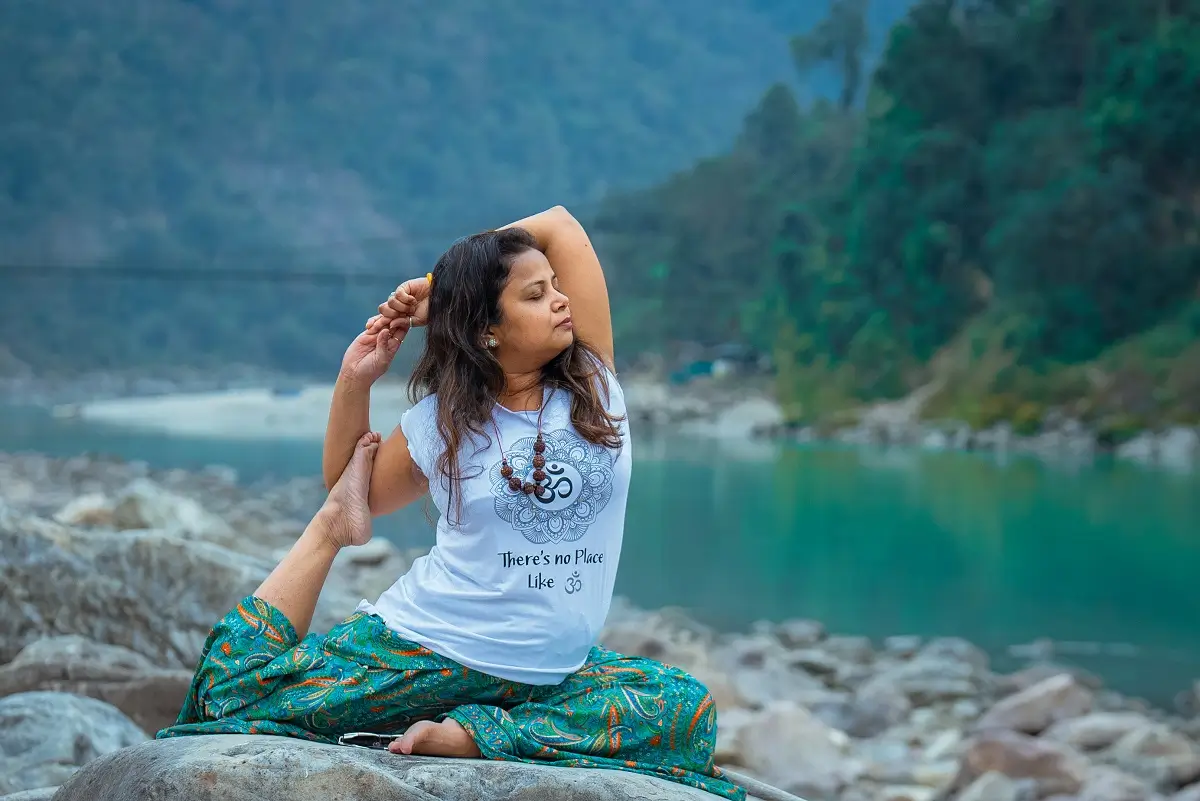 Group yoga class practising Warrior pose outdoors at a retreat in Rishikesh, India